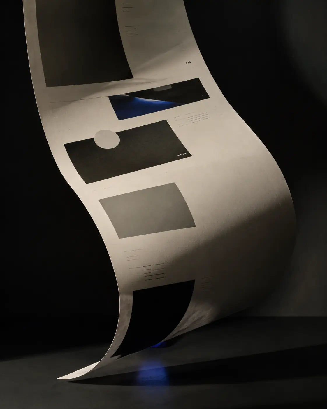 An editorial website composition printed across a curved sheet of paper